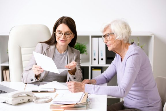 Senior woman reviewing paperwork with an advisor